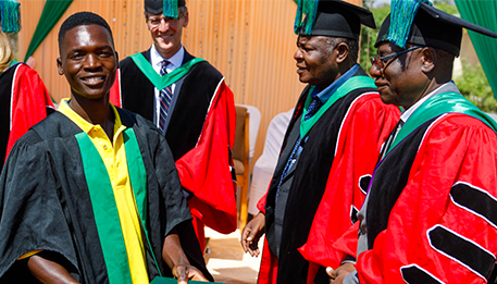 670x300_Day3_08_NuSkin School of Agriculture for Family Independence (SAFI) students in their graduation gowns receive their diplomas.